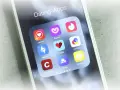 Smartphone-Bildschirm mit Icons verschiedener Dating-Apps wie Tinder, Badoo und Lovoo.